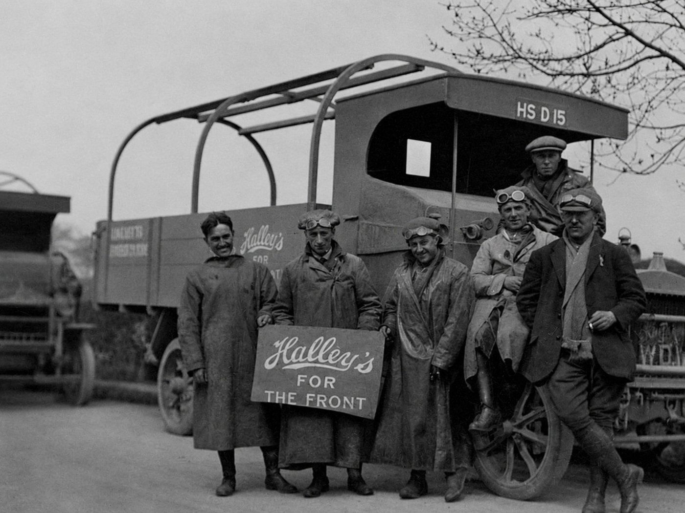 Historic Halley workers beside a vehicle holding a Halleys for the Front sign